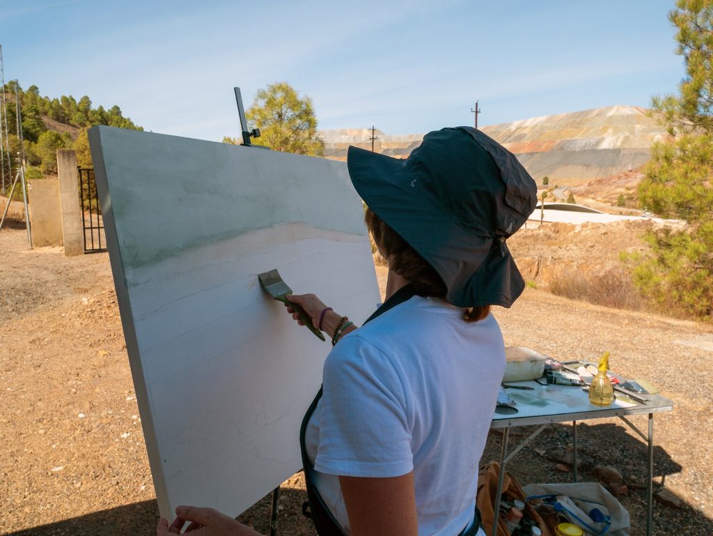 Artista creando una obra ante el entorno minero